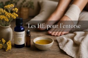 Une composition à plat sur une table en bois rustique avec une bouteille d'huile essentielle d'hélichryse, un roll-on, un bol de macérat d'arnica, un linge en lin, et en arrière-plan les pieds d'une femme dont une cheville bandée repose sur un coussin, avec un texte superposé 'Les HE pour l'entorse'.